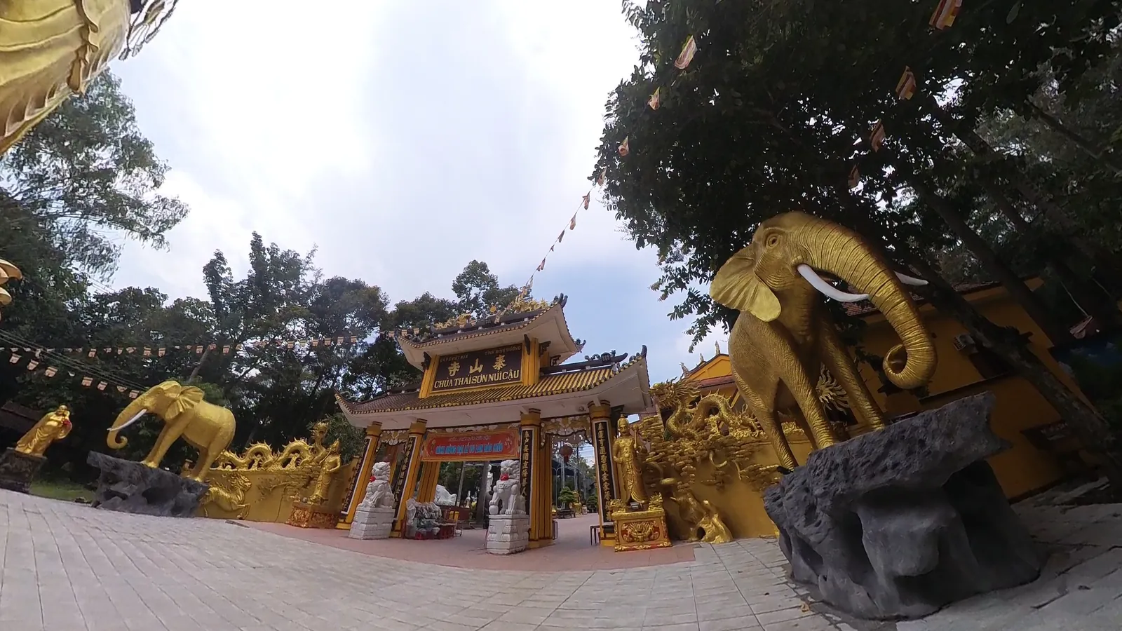 泰山寺金色山门，匾上写汉字泰山寺，下面一行越南语 CHÙA THÁI SƠN NÚI CẬU